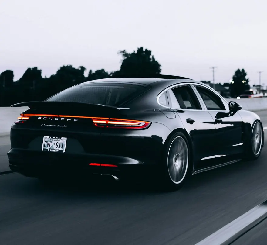 Voiture de sport noire sur la route après un detailing complet